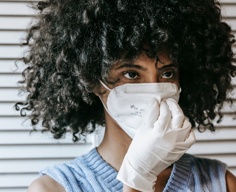 A black lady in a mask and gloves in her home during the coronavirus pandemic