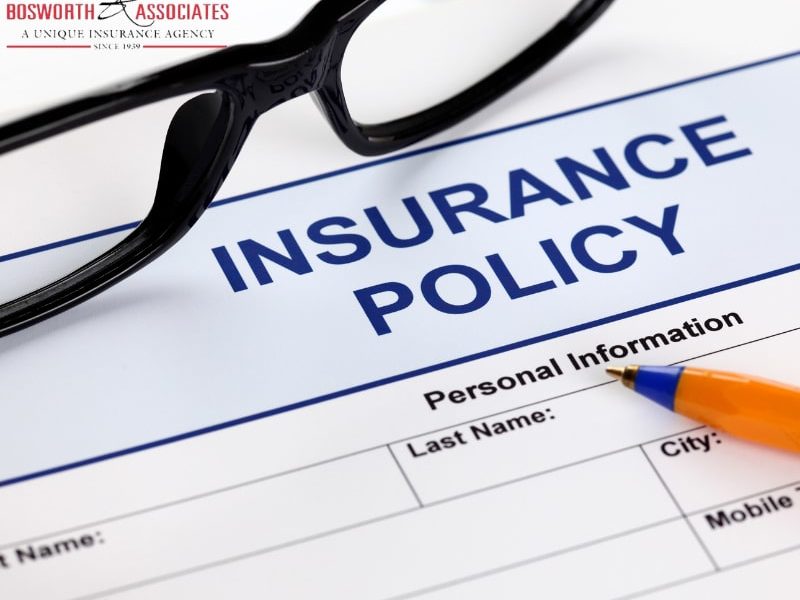 An insurance policy form with glasses and a pen.