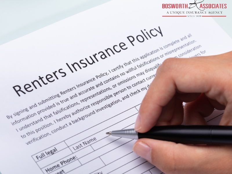 A person filling out a renters insurance policy form.