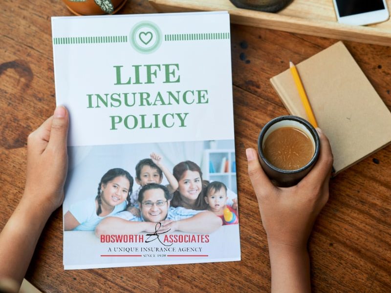 A person holds a Family life insurance policy prospect and a cup of coffee.