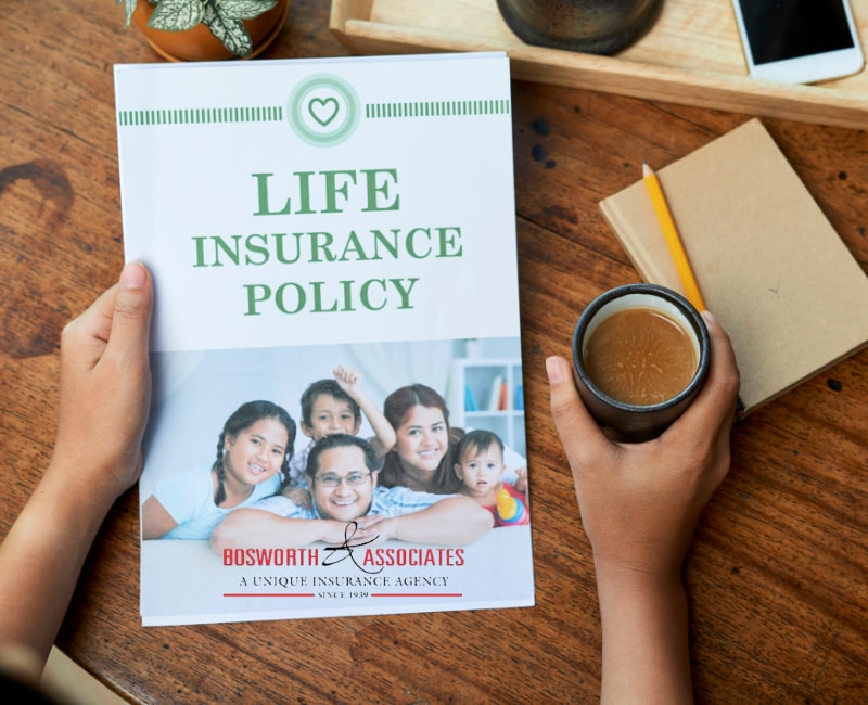 A person holds a Family life insurance policy prospect and a cup of coffee.