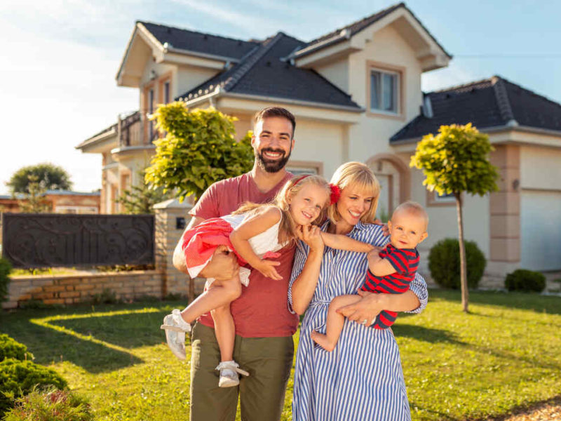 family on front lawn of their home