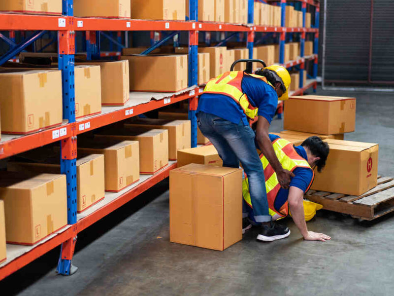 injured warehouse worker being helped by another worker
