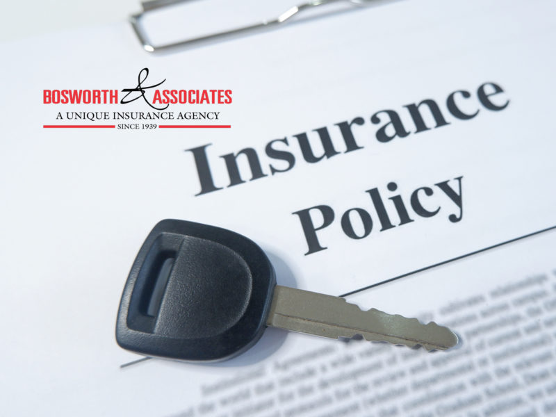 Car key resting on auto insurance policy document, Bosworth & Associates insurance agency