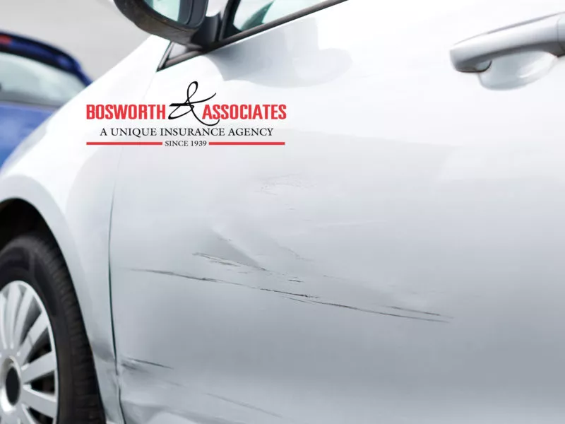Bosworth & Associates logo over a silver car door with a dent and long scratches from a minor collision